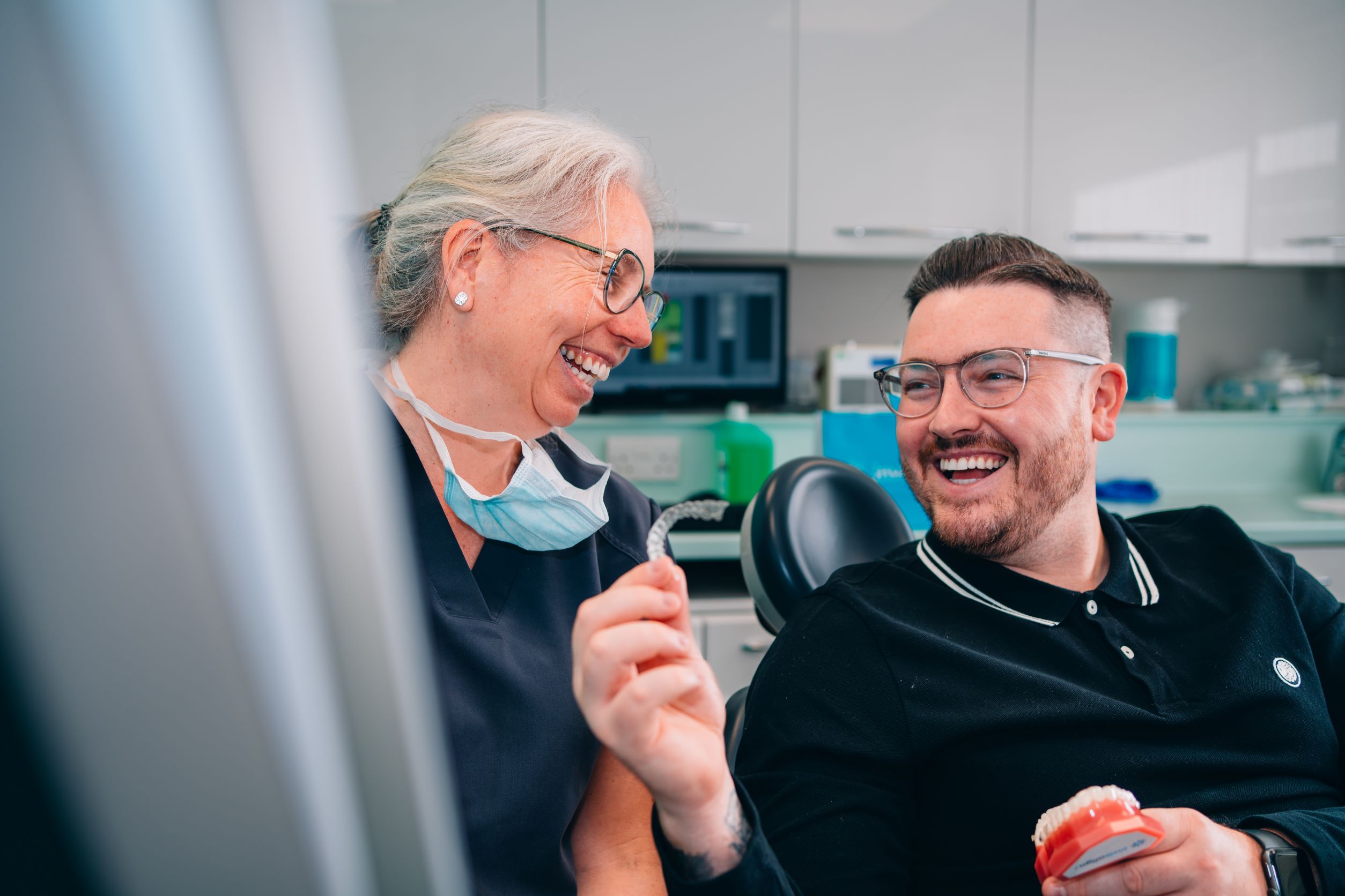 Dentist showing a patient a dental model at Hest Bank Dental Care